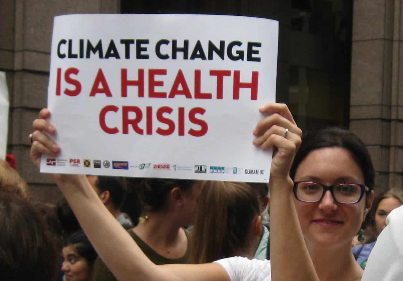 Dr. Lauren Zajac holding sign: "Climate Change Is a Health Crisis"